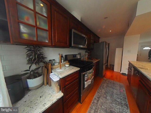 2710 N 47th St, Philadelphia, PA 19131 - kitchen with stainless steel appliances, dark brown cabinets, light wood-style floors, light stone countertops, and recessed lighting