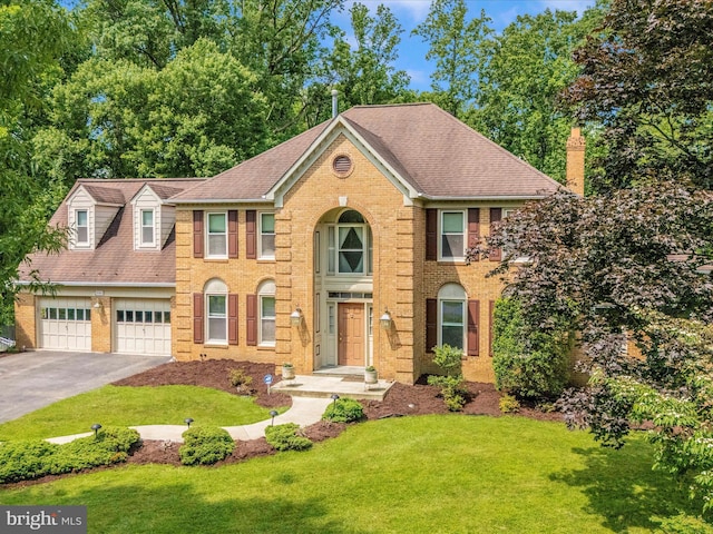 608 Silverstone Ct, Silver Spring, MD 20905 - colonial inspired home with asphalt driveway, a front lawn, brick siding, a chimney, and roof with shingles
