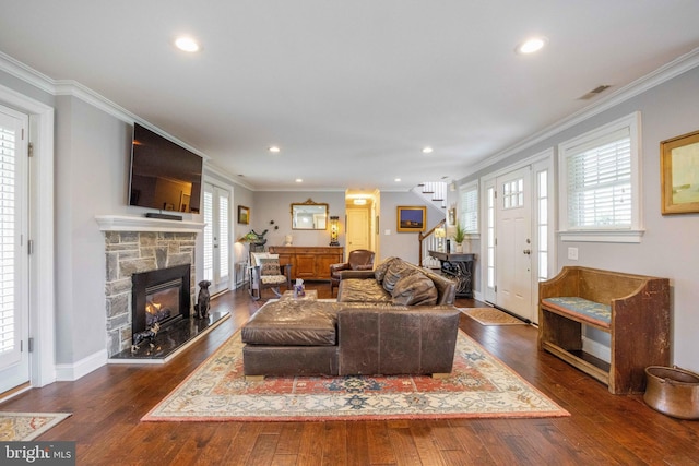 living area with stairway, visible vents, ornamental molding, and dark wood finished floors