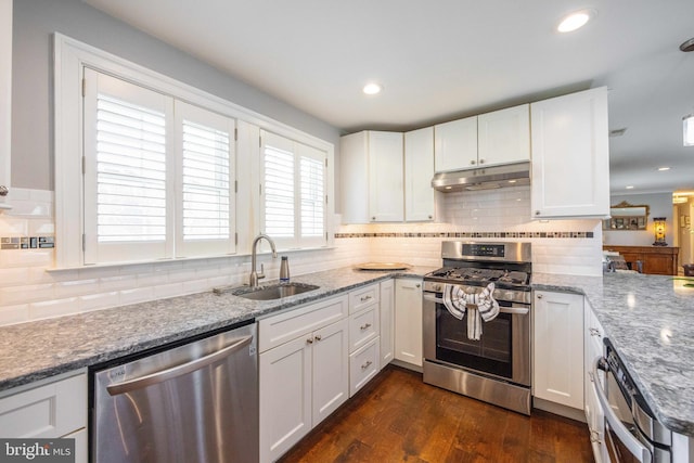 kitchen with a sink, white cabinetry, under cabinet range hood, and stainless steel appliances