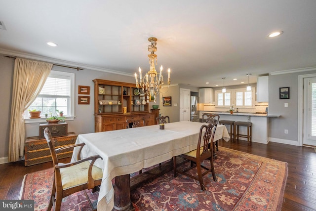 dining room with an inviting chandelier, recessed lighting, crown molding, and dark wood finished floors