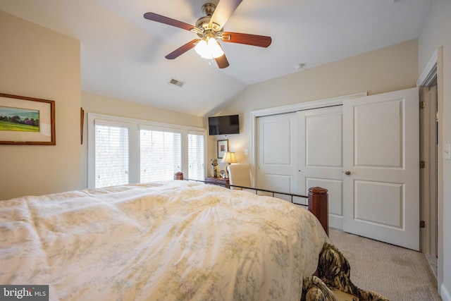 bedroom with visible vents, a closet, a ceiling fan, vaulted ceiling, and light carpet