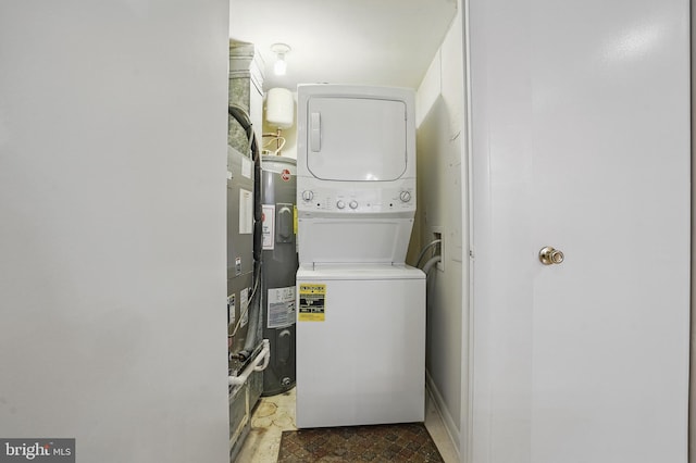 laundry room with stacked washer and dryer, laundry area, and water heater