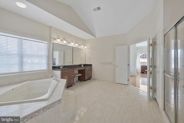 full bath featuring a garden tub, a shower stall, vaulted ceiling, vanity, and tile patterned floors