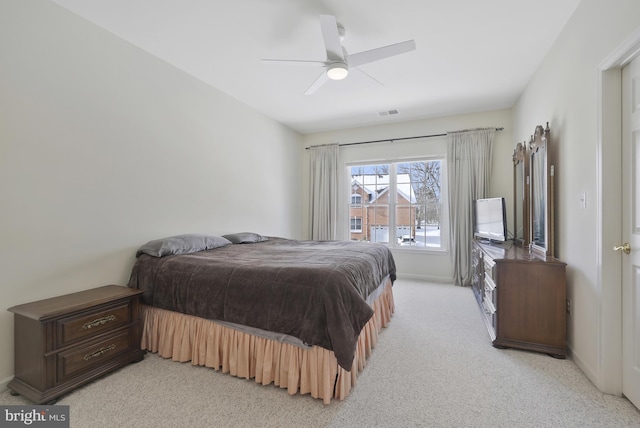bedroom featuring ceiling fan, light colored carpet, and baseboards