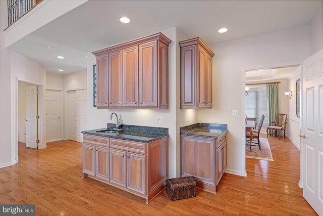 kitchen featuring recessed lighting, brown cabinetry, a sink, and light wood-type flooring