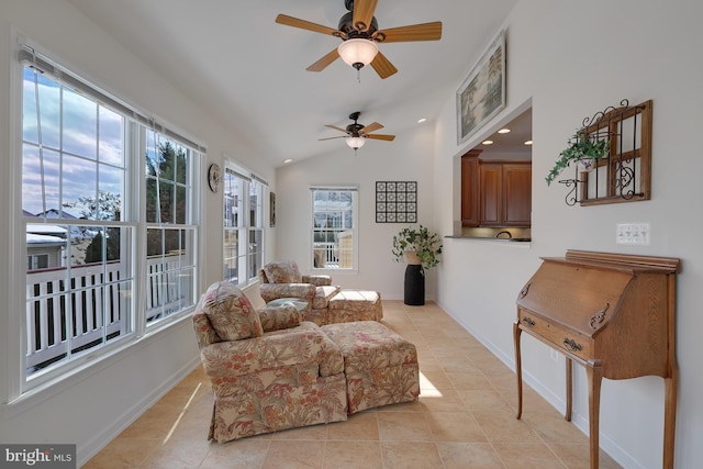 living area featuring baseboards, a ceiling fan, light tile patterned floors, and vaulted ceiling