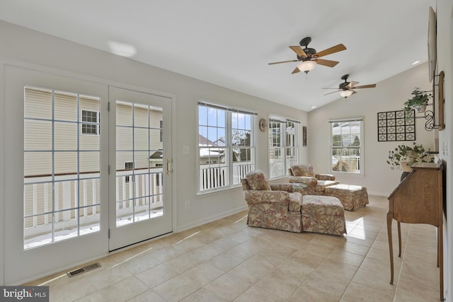 living room with ceiling fan, visible vents, vaulted ceiling, light tile patterned floors, and baseboards
