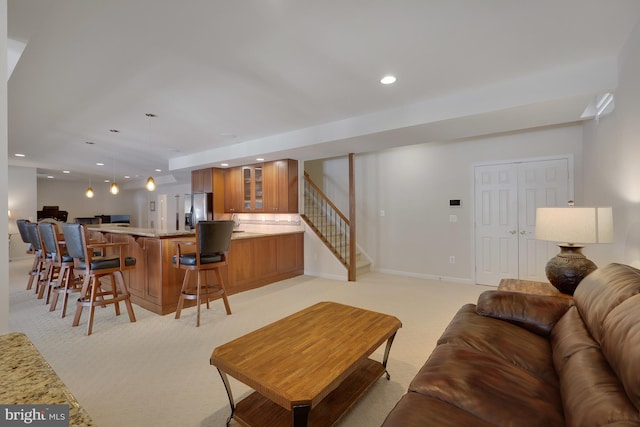living room featuring recessed lighting, stairs, baseboards, and light carpet