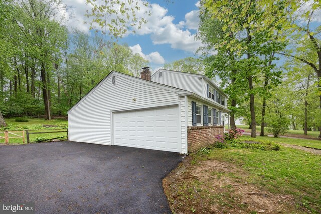 304 King Rd, West Chester, PA 19380 - view of property exterior featuring aphalt driveway, fence, brick siding, a garage, and a chimney