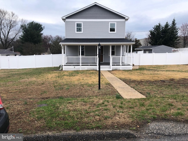 view of front of property featuring a front yard, covered porch, and fence