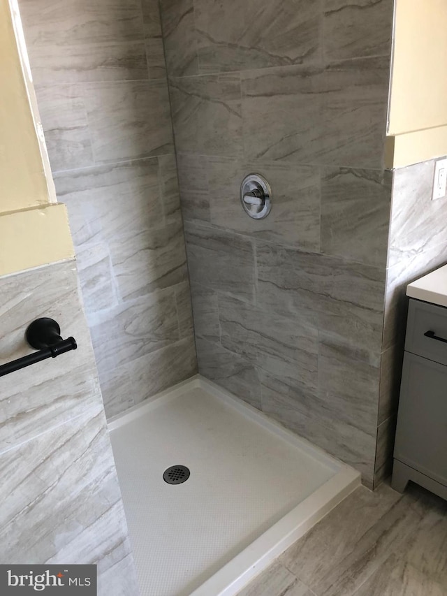 full bathroom featuring vanity and a tile shower