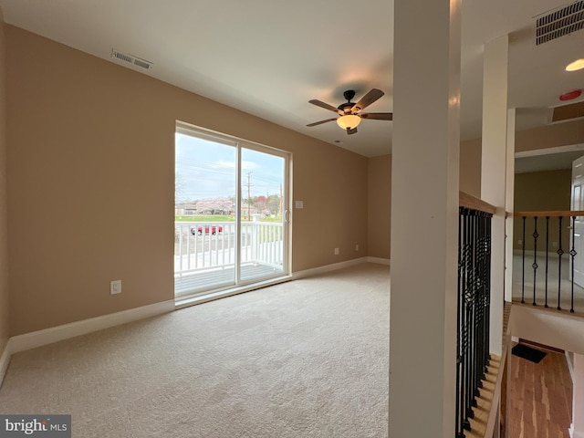 carpeted empty room with a ceiling fan, baseboards, and visible vents