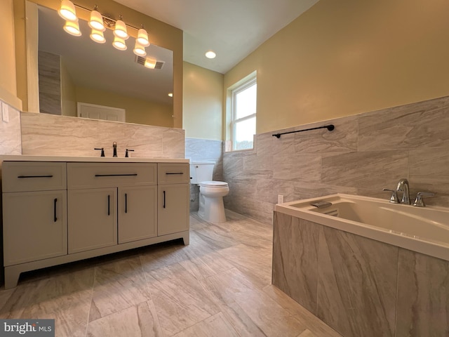 full bathroom with vanity, tile walls, toilet, visible vents, and a bath