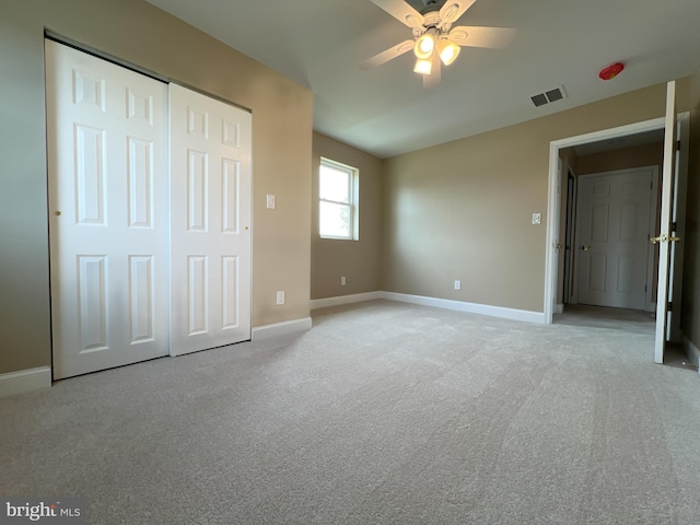 unfurnished bedroom with light colored carpet, a closet, a ceiling fan, baseboards, and visible vents