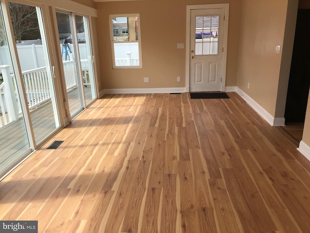 interior space with baseboards, visible vents, and light wood-type flooring