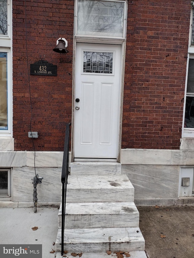 doorway to property featuring brick siding