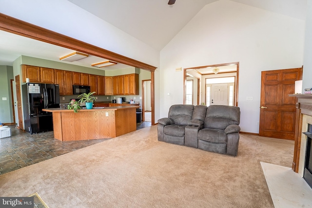 living area featuring dark colored carpet, baseboards, high vaulted ceiling, and a high end fireplace