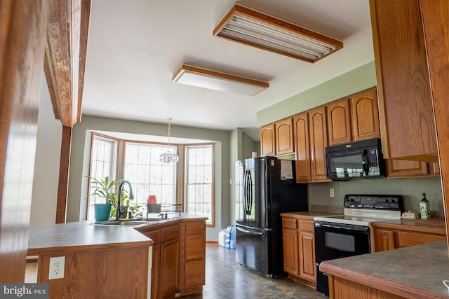 kitchen with brown cabinets, hanging light fixtures, a sink, and black appliances