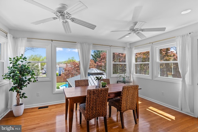 sunroom / solarium with plenty of natural light, visible vents, a deck, and baseboards