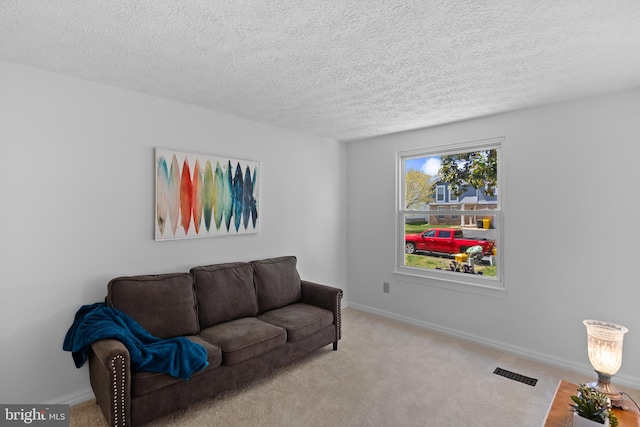 carpeted living area featuring a textured ceiling, visible vents, and baseboards