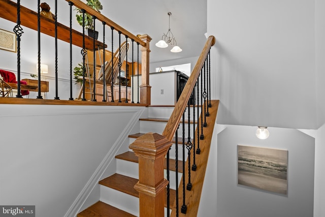 stairway featuring an inviting chandelier