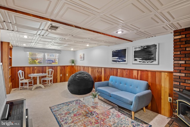 living room with a wood stove, an ornate ceiling, a wainscoted wall, and wooden walls