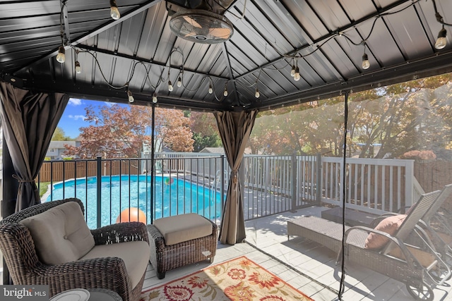 view of patio / terrace featuring fence, a fenced in pool, and a gazebo