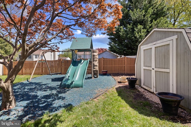 view of jungle gym featuring a fenced backyard, an outdoor structure, and a storage shed