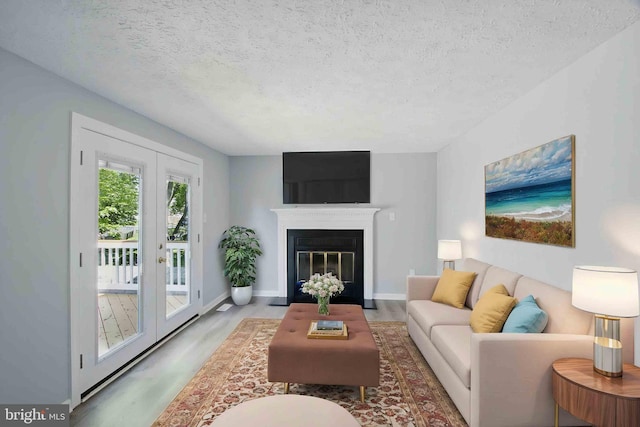 5694 Singletree Dr, Frederick, MD 21703 - living area with a textured ceiling, wood finished floors, french doors, baseboards, and a fireplace with flush hearth
