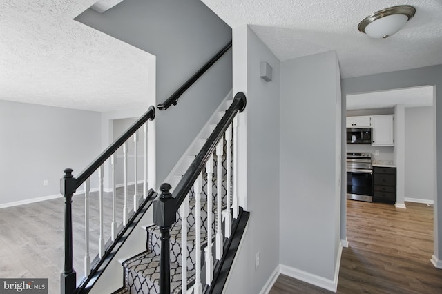 5694 Singletree Dr, Frederick, MD 21703 - staircase with a textured ceiling, wood finished floors, and baseboards