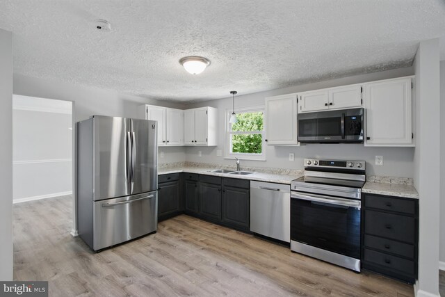 5694 Singletree Dr, Frederick, MD 21703 - kitchen with stainless steel appliances, a sink, white cabinetry, light wood-style floors, and a textured ceiling