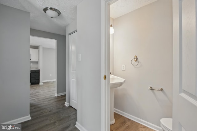 5694 Singletree Dr, Frederick, MD 21703 - half bath with wood finished floors, a textured ceiling, baseboards, and toilet