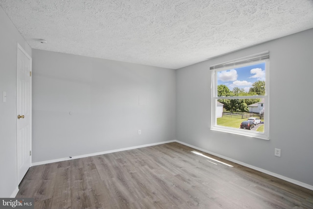 5694 Singletree Dr, Frederick, MD 21703 - spare room with wood finished floors, a textured ceiling, and baseboards