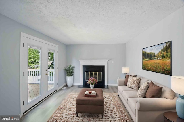 5694 Singletree Dr, Frederick, MD 21703 - living area with wood finished floors, a textured ceiling, french doors, and baseboards