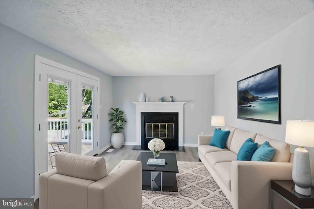 5694 Singletree Dr, Frederick, MD 21703 - living room with wood finished floors, a textured ceiling, baseboards, french doors, and a fireplace with flush hearth