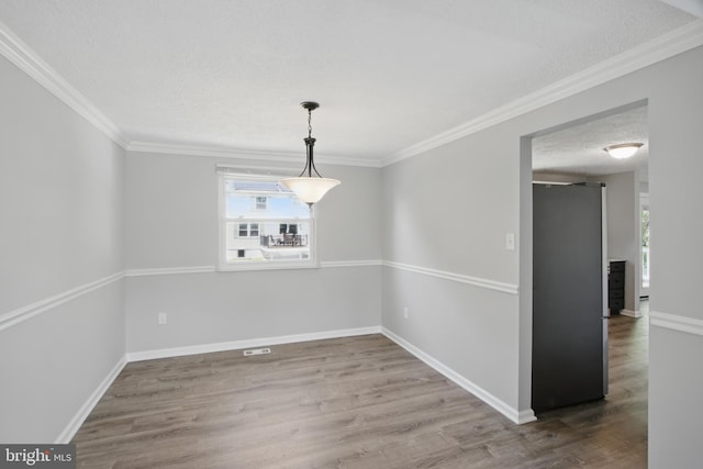 5694 Singletree Dr, Frederick, MD 21703 - unfurnished dining area featuring plenty of natural light, wood finished floors, a textured ceiling, baseboards, and ornamental molding