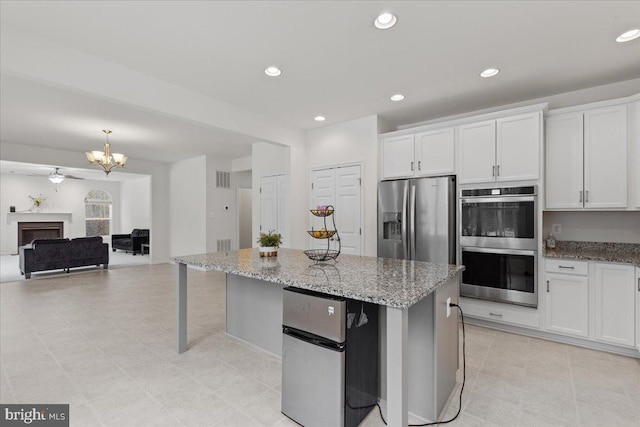 kitchen featuring white cabinetry, appliances with stainless steel finishes, light stone counters, and recessed lighting