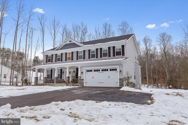 view of front facade featuring stone siding, covered porch, a garage, and driveway