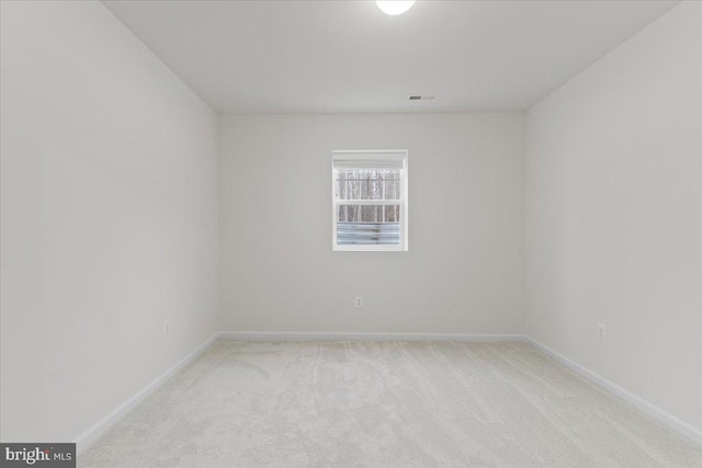 unfurnished room with baseboards, visible vents, and light colored carpet
