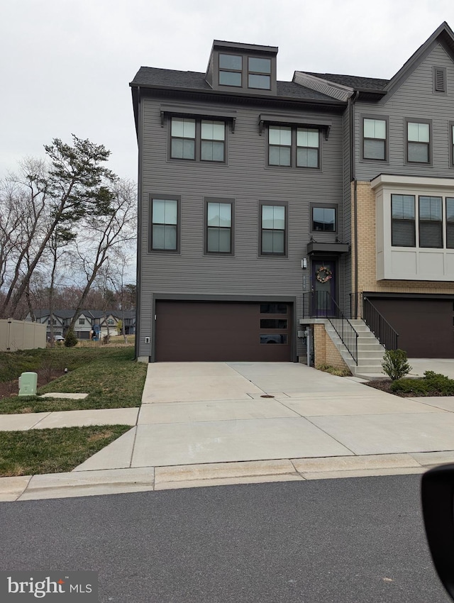multi unit property featuring a garage and concrete driveway