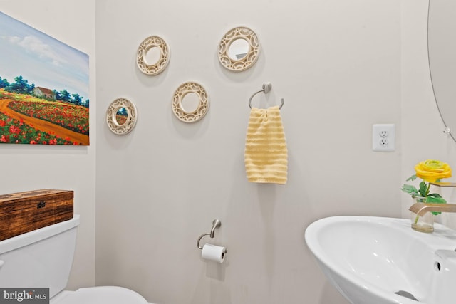 half bathroom featuring a sink and toilet