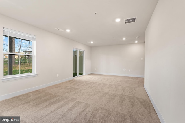 spare room with recessed lighting, baseboards, visible vents, and light colored carpet