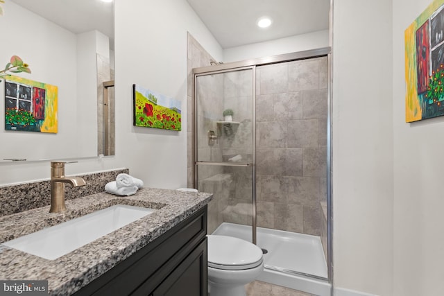 bathroom with recessed lighting, toilet, vanity, and a stall shower