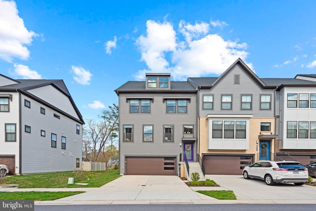 townhome / multi-family property with concrete driveway and a garage