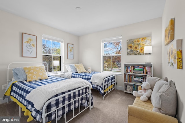 carpeted bedroom featuring baseboards and multiple windows