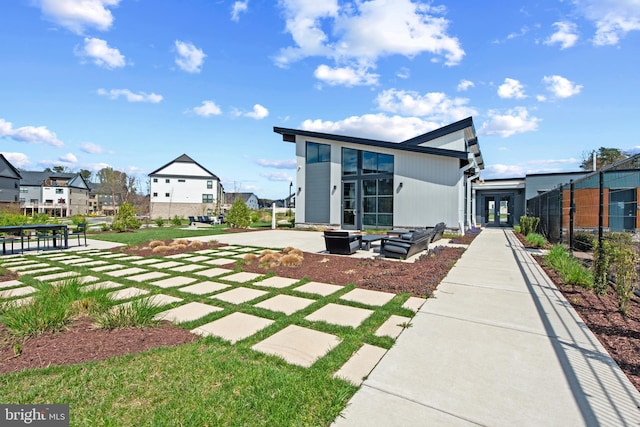 back of property with fence, french doors, and a residential view