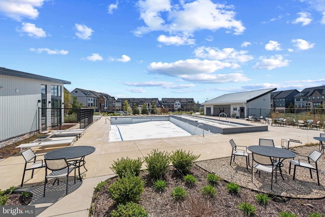community pool featuring a residential view, a patio, and fence