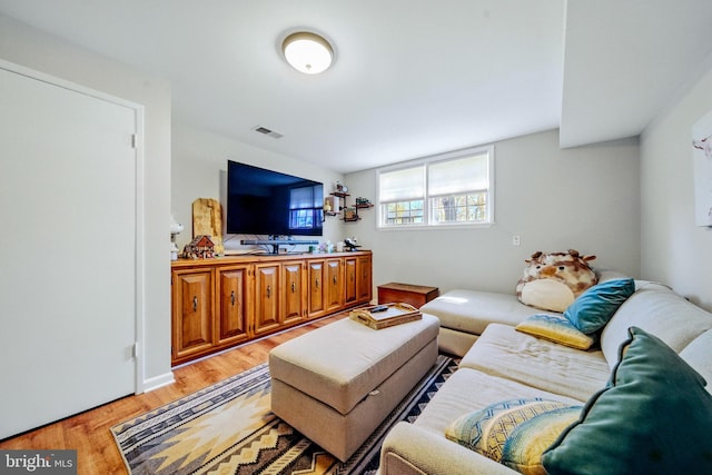 living area featuring light wood finished floors and visible vents