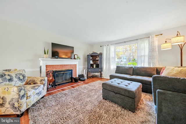 living area featuring wood finished floors and a brick fireplace